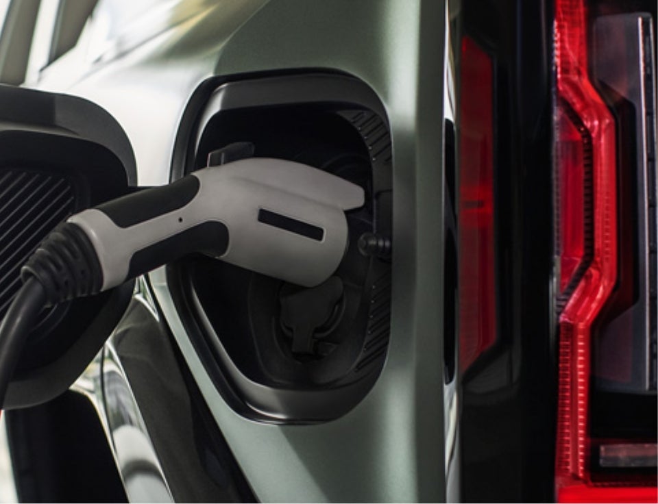 Close up of charging port with charger plugged in on a GMC Hummer EV SUV - Fox Auto Group GMC in PAINTED POST NY